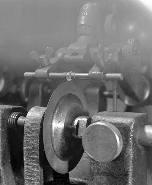 Molette (lame) d'une scie et diamant, vus de trois quarts.Pris entre deux mors, le diamant est au contact du disque en bronze phosphoreux. © Jérôme Mongreville / Région Bourgogne-Franche-Comté, Inventaire du patrimoine - 2001