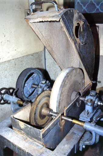 Vue d'ensemble de la partie supérieure, capot ouvert (cadrage vertical).Prise entre pointe et contre-pointe, la meule métallique frotte contre la meule abrasive. © Jérôme Mongreville / Région Bourgogne-Franche-Comté, Inventaire du patrimoine - 2001