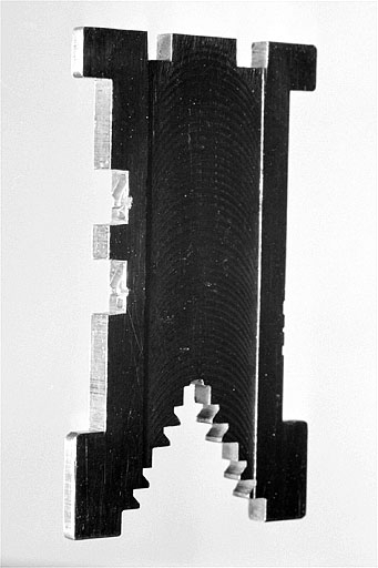 Matrice de caractères, de trois quarts. La matrice est duplexée : le côté droit est entaillé par les moules de deux caractères. © Jérôme Mongreville / Région Bourgogne-Franche-Comté, Inventaire du patrimoine - 2002