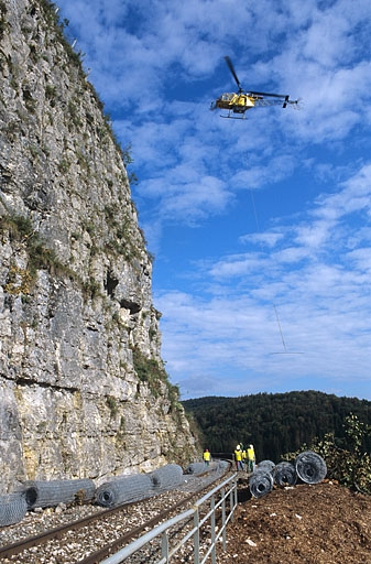 Sécurisation de paroi rocheuse à Syam : hélicoptère venant chercher un rouleau de filet de protection. © Yves Sancey / Région Bourgogne-Franche-Comté, Inventaire du patrimoine - 2004 Sécurisation de paroi rocheuse à Syam : hélicoptère venant chercher un rouleau de filet de protection. © Yves Sancey / Région Bourgogne-Franche-Comté, Inventaire du patrimoine - 2004