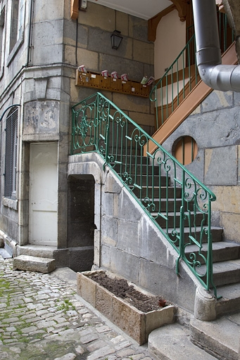 Escalier à cage ouverte sur cour : détail de la rampe en fer forgé de la première volée. © Yves Sancey / Région Bourgogne-Franche-Comté, Inventaire du patrimoine - 2011