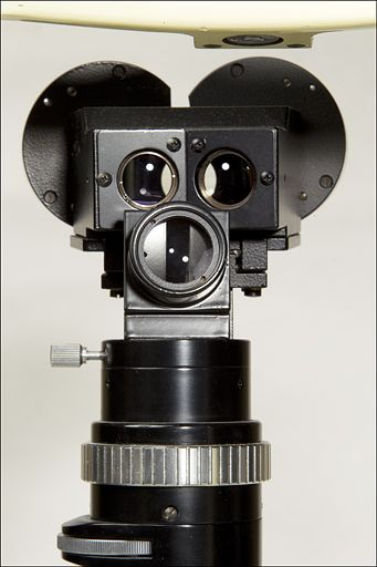 Détail de la partie optique, vue du côté du patient : objectifs et partie arrière de la binoculaire en haut, module d'éclairage et son objectif en bas. © Yves Sancey / Région Bourgogne-Franche-Comté, Inventaire du patrimoine - 2011