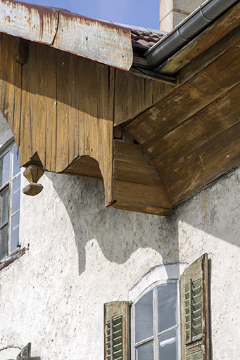 Façade antérieure : extrémité droite de la lambrichure et motif décoratif ornant l'extrémité pendante d'un poteau. © Sonia Dourlot / Région Bourgogne-Franche-Comté, Inventaire du patrimoine - 2015 Façade antérieure : extrémité droite de la lambrichure et motif décoratif ornant l'extrémité pendante d'un poteau. © Sonia Dourlot / Région Bourgogne-Franche-Comté, Inventaire du patrimoine - 2015