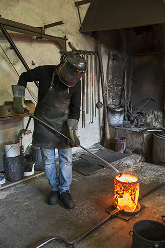 Poche de bronze en fusion. L'opérateur retire le laitier (scories) (1). © Jérôme Mongreville / Région Bourgogne-Franche-Comté, Inventaire du patrimoine - 2015