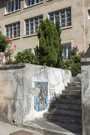 Façade sud : escalier donnant sur la Grande Rue. Sur le mur sont peintes les armoiries de la Franche-Comté, accompagnées de la date du rattachement de cette région à la France. © Sonia Dourlot / Région Bourgogne-Franche-Comté, Inventaire du patrimoine - 2016